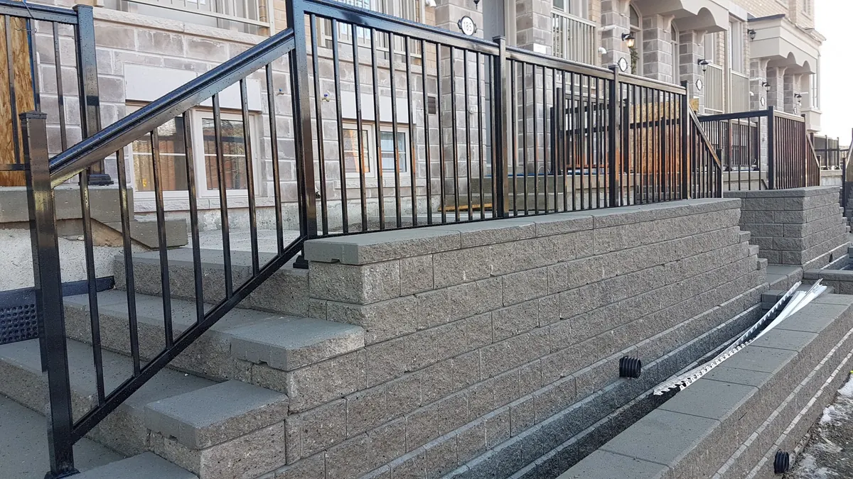 Black aluminum railing on multi-tier concrete stair entry