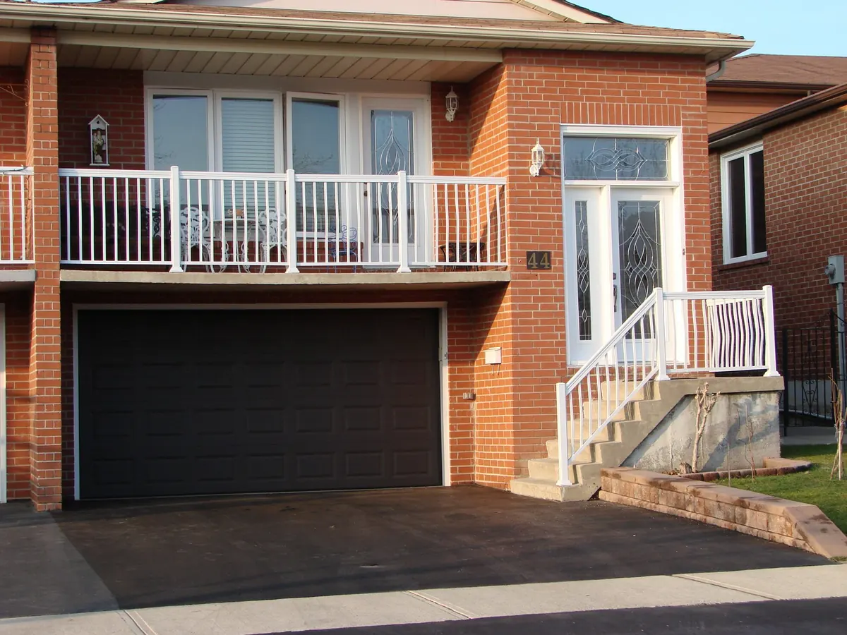 White aluminum front-porch railing with matching balcony above on red-brick home