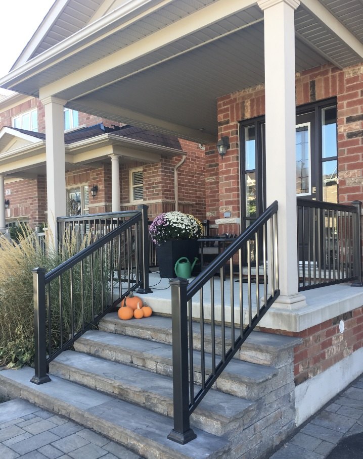 R1 black aluminum railing on a brick front porch with autumn pumpkins